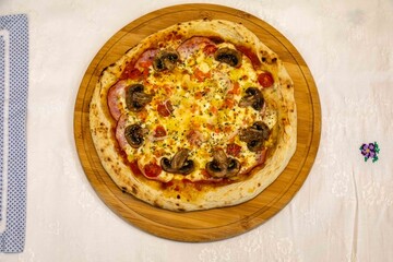 Traditional Brazilian pizza with Canadian pork loin and mushrooms in a rustic, artisanal, long-fermented dough baked in a wood-fired oven.