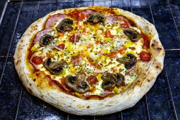 Traditional Brazilian pizza with Canadian pork loin and mushrooms in a rustic, artisanal, long-fermented dough baked in a wood-fired oven.