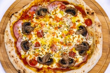 Traditional Brazilian pizza with Canadian pork loin and mushrooms in a rustic, artisanal, long-fermented dough baked in a wood-fired oven.