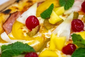 The iconic, wonderful, and unique California pizza, made with Canadian pork tenderloin and tropical fruits—pineapple, mango, fig, peach, and cherries—garnished with fresh mint leaves. 