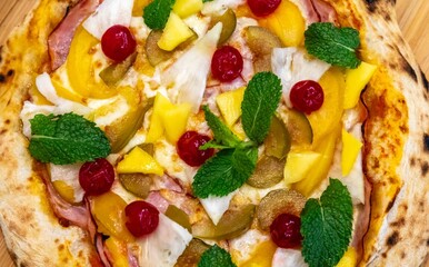 The iconic, wonderful, and unique California pizza, made with Canadian pork tenderloin and tropical fruits—pineapple, mango, fig, peach, and cherries—garnished with fresh mint leaves. 