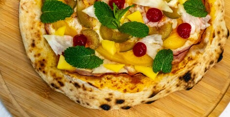 The iconic, wonderful, and unique California pizza, made with Canadian pork tenderloin and tropical fruits—pineapple, mango, fig, peach, and cherries—garnished with fresh mint leaves. 