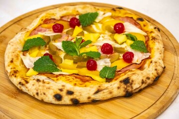 The iconic, wonderful, and unique California pizza, made with Canadian pork tenderloin and tropical fruits—pineapple, mango, fig, peach, and cherries—garnished with fresh mint leaves. 