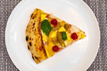 The iconic, wonderful, and unique California pizza, made with Canadian pork tenderloin and tropical fruits—pineapple, mango, fig, peach, and cherries—garnished with fresh mint leaves. 