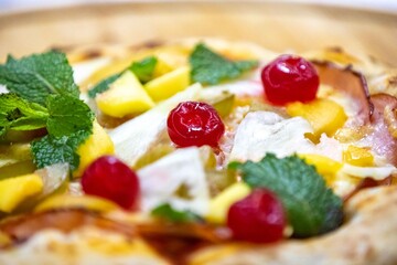 The iconic, wonderful, and unique California pizza, made with Canadian pork tenderloin and tropical fruits—pineapple, mango, fig, peach, and cherries—garnished with fresh mint leaves. 