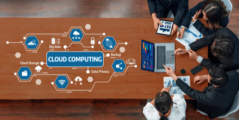 A group of professionals engaged in a meeting focused on cloud computing strategies, utilizing visual data analysis and technology in a modern office environment. Amity