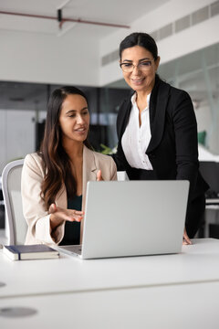 Young project manager showing online report to senior female boss