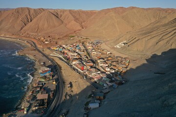 Aerial drone videos of a small fishing cove with boats and desert coastline near Antofagasta, northern Chile