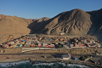 Aerial drone videos of a small fishing cove with boats and desert coastline near Antofagasta, northern Chile