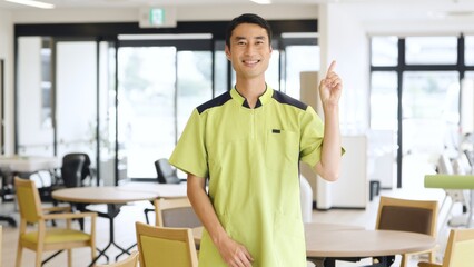 介護施設で指差しをするアジア人介護福祉士