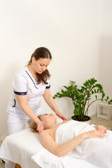 Massage therapist gives woman oil massage. 