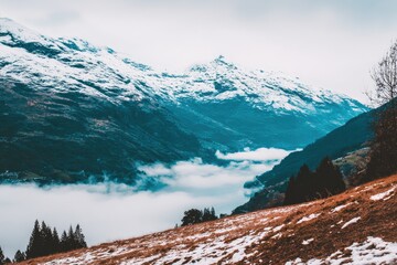 Snow-capped mountains, valley shrouded in mist