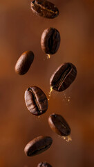 Fototapeta premium Dark roasted coffee beans falling with golden liquid droplets