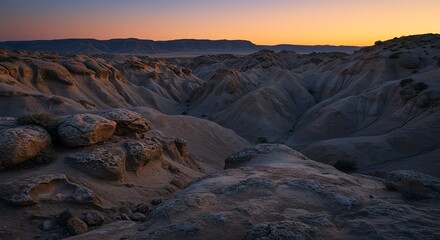 Obraz premium Desert landscape at sunset with eroded rock formations
