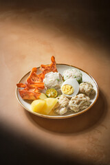 Plate of siomay with side dishes suitable for food blogs, restaurant menus, asian cuisine articles, indonesian cuisine promotions, cooking magazines.