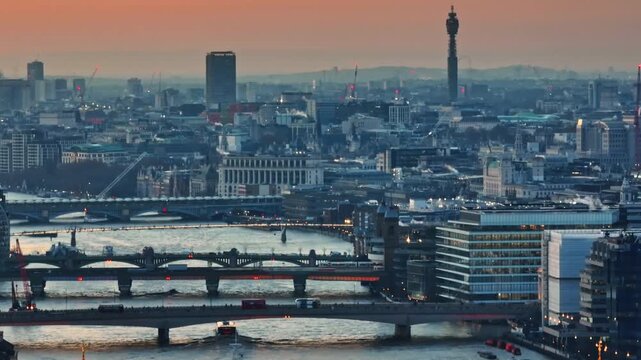 England, London: Aerial view urban city landscape with the BT Tower, River Thames, buildings and bridges during vibrant sunset. Drone footage panorama. Blue evening color toning. Drone flight footage