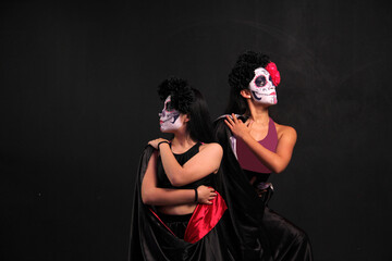 Two young women dancers dressed as catrinas to celebrate the Day of the Dead festival in Mexico
