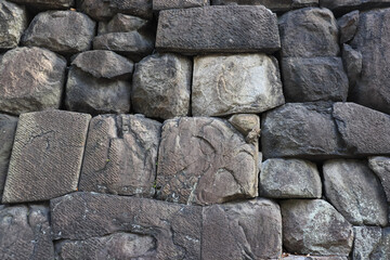 A close-up of stone and other materials, with random shapes arranged in succession to create an interesting design.