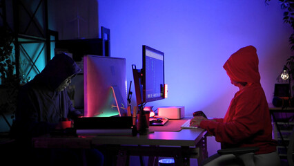 Senior couple wearing headsets and enjoying online gaming together in a neon lit room