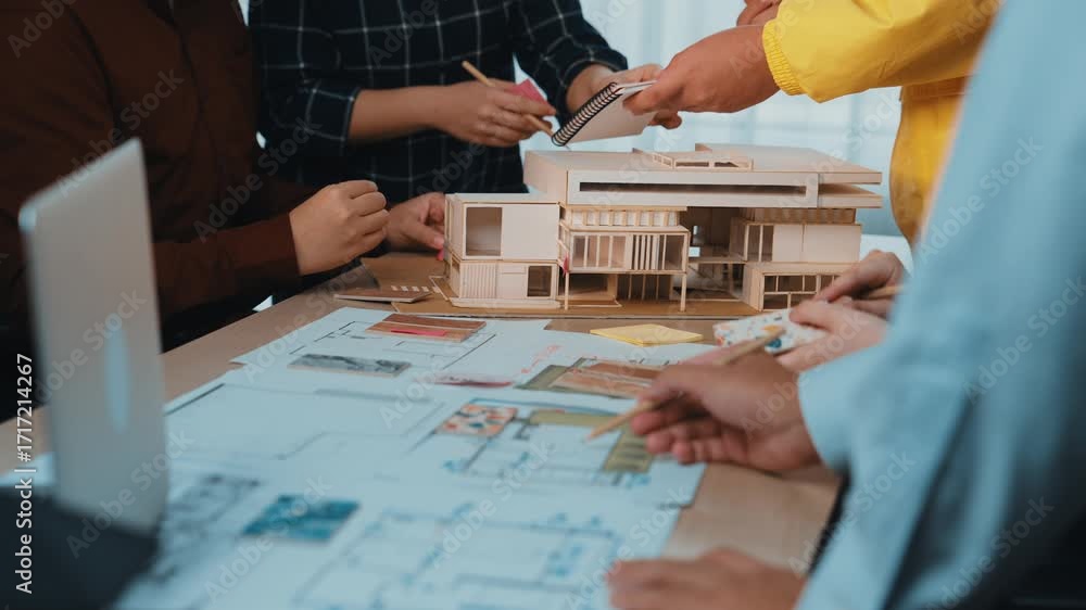 Poster a group of professionals engaged in a collaborative meeting focused on architectural design, utilizi