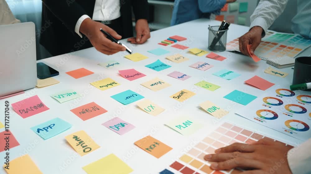 Poster a diverse team collaborates in a modern office environment, utilizing colorful sticky notes for brai