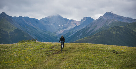 Riding mountain bike on grassland mountain top