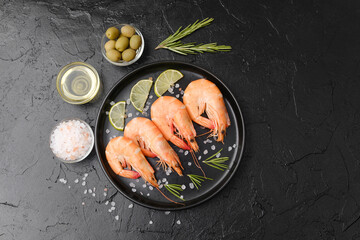Shrimp served with rosemary, salt and olives on black plate for gourmet appetizer or restaurant...