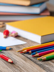 colorful arrangement of art supplies, including pencils and a blank notebook, on a rustic wooden surface, ideal for creative projects.