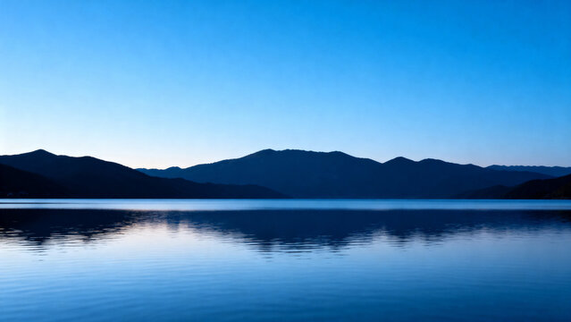 Calm lake reflecting mountains under a clear blue sky - Powered by Adobe