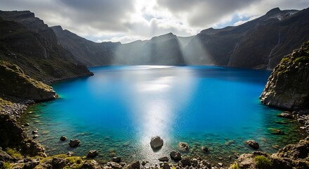 Serene mountain lake with dramatic clouds and sunlight rays.