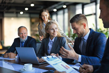 Group of business partners discussing ideas and planning work in office.