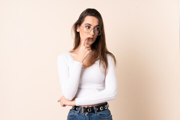 Young woman over isolated beige background nervous and scared