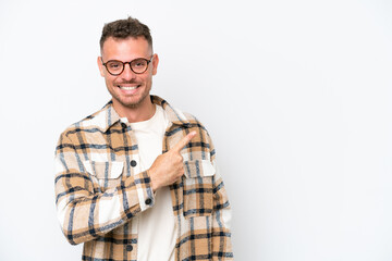 Young caucasian handsome man isolated on white background pointing to the side to present a product