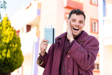 Young caucasian man holding a passport at outdoors whispering something