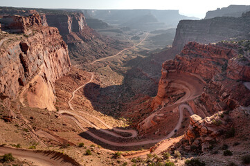 Shafer Trail Viewpoint, Canyon overlook with dirt road winding down along the side of a cliff in Canyonlands National Park, Utah, United States.