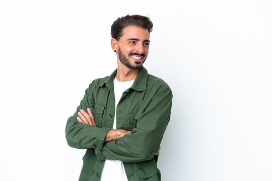 Young caucasian man isolated on white background with arms crossed and happy