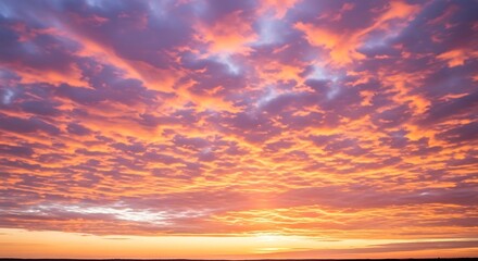 Fototapeta premium Dramatic sunset with vibrant orange and purple clouds filling the sky.