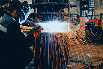 beautiful sparks from metal welding. A working welder welds seams on a new engine for an airplane. Industrial factory complex of aircraft construction and turbines of the new generation. High quality © Rystemys