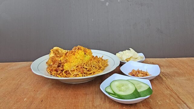bowl of nachos,Nasi kuning or Yellow rice or Indonesian turmeric rice served with fried noodles,fried egg,spicy fried tempeh,fresh cucumber and melinjo crackers ,Javanese yellow rice set menu