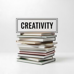 A stack of books, topped with a sign displaying the word "creativity", against a plain white background.