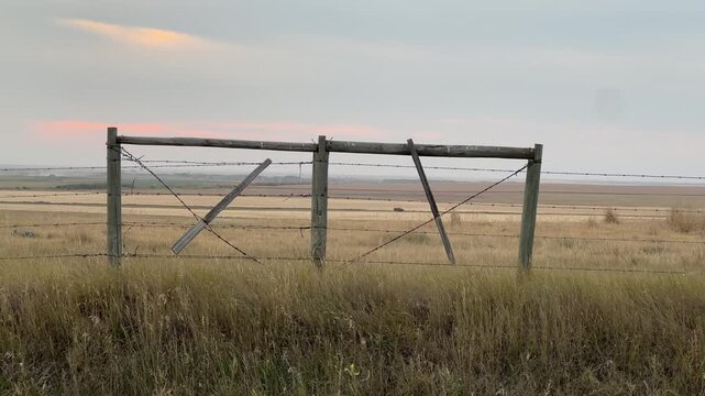 Rustic wooden farm fencing stretching across open agricultural land, highlighting rural countryside boundaries, livestock enclosures, and traditional farm life in Alberta, Canada.