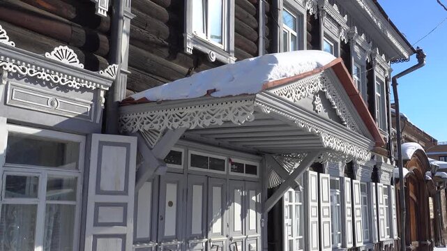 Irkutsk's 130th Quarter with historic wooden log houses. Authentic Siberian architecture featuring intricate wood carvings, traditional timber framing in snowy landscape. Cultural heritage site 4k