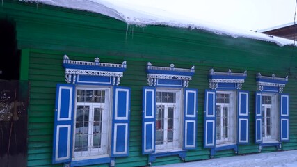 Gimbal winter historic wooden houses with carved shutters in Irkutsk, Siberia. Authentic Slavic architecture during snowstorm, preserving untouched traditional style and cultural heritage nostalgia