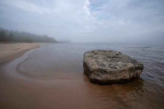 Priozersk Lake Ladoga.A huge kayak on the beach with fog on the horizon.Morning at the lake.