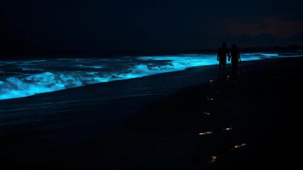 Couple Walking on Bioluminescent Beach at Night with Glowing Waves and Footprints - Powered by Adobe