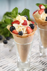 Japanese crepes with whipped cream filling, strawberries, blueberries, almond petals, garnished with mint.  