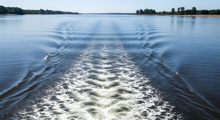 white foamy boat wake trailing on a wide river
