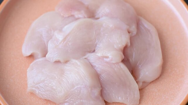 Slices of raw chicken or turkey breast, skinless and boneless. Chicken breast slices are a high-protein food