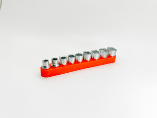 Naklejka premium A neatly organized set of socket wrenches on a red rail, ideal for automotive repairs or DIY projects.