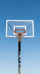 Naklejka premium A basketball hoop and backboard stand tall against a clear, vibrant blue sky.